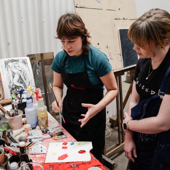 Artists Kate Kurucz and Kat Korossy painting in art workshop